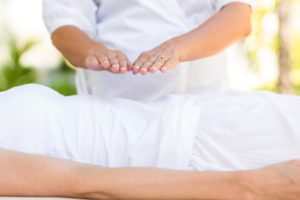 Calm woman receiving reiki treatment in the health spa